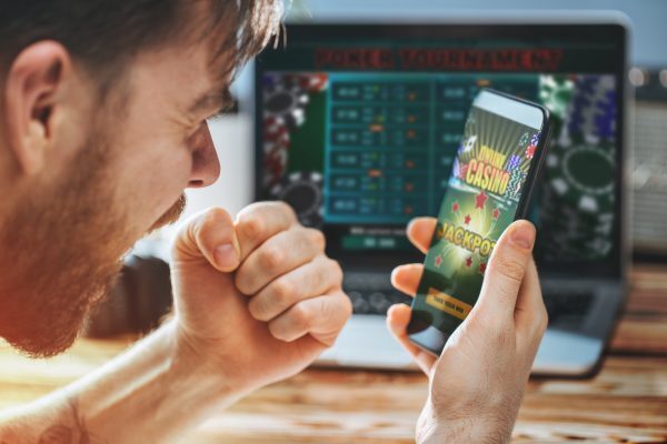 An Australian man celebrating winning playing an online casino game