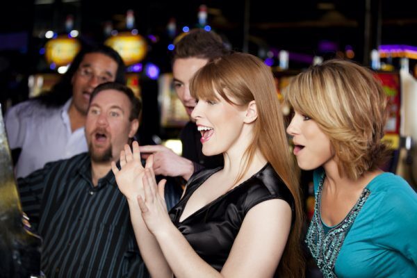 group of players around a progressive pokie machine